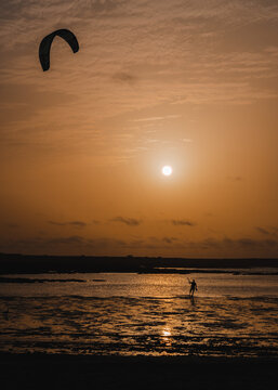 Kite surfing around the cotillo beach lighthouse in a sunset
