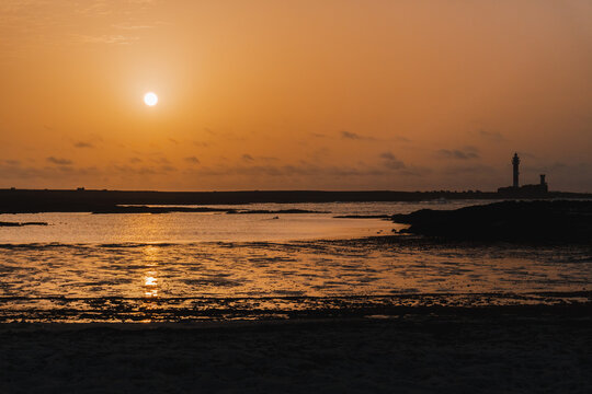 Sunset in a cove of Cotillo, Fuerteventura, with the lighthouse in the background