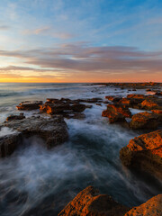 Fototapeta na wymiar Sunrise view at the rocky beach coastline.