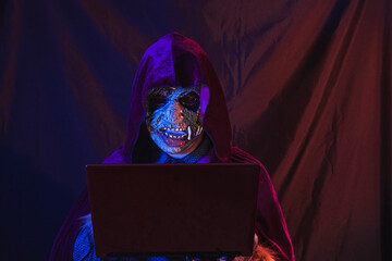 Hooded monster using his laptop