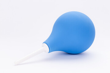 Enema for cleaning intestines and treating diseases of digestive system and cleaning body. Medical pear rubber blue enema on white background.