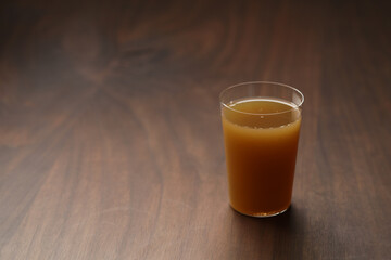 Apple celery juice in thin glass on wood table