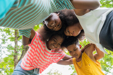 Group happy African American childrens having fun and embracing together in the park