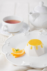 Fototapeta premium Sweets cake orange soufflé with tea. Photo of food on a white background
