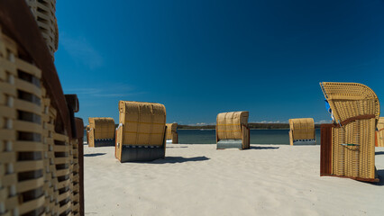 Beach baskets with sunshine, blue sky and turquoise ocean behind on a beach in northern Germany