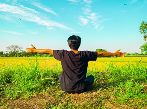 Asian youth meditate for a healthy lifestyle. Asian man doing yoga meditation in sitting position with arms outstretched wide beautiful nature in the morning