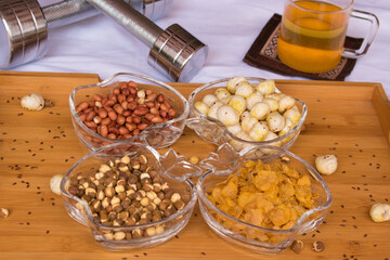 Healthy Indian Snacks for slim fit with herbal tea and dumbbells sport equipment for healthy lifestyle women. Weight Loss and Diet Concept. healthy fitness and eating lifestyle. selective focus.