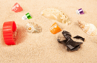 Fototapeta na wymiar image of battery plastic garbage seashell sand background