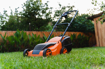 A lawnmower on a grass in a backyard during the day