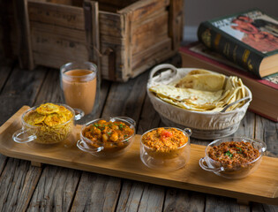 Assorted break fast set balalet or balaleet, aloo nakhi,aloo karahi, tomato egg, foul medames with bread and coffee served in a dish isolated on cutting board side view of breakfast on background