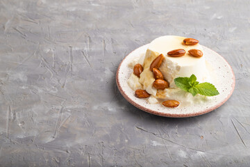 Ricotta cheese with honey and almonds on gray concrete. side view, copy space.