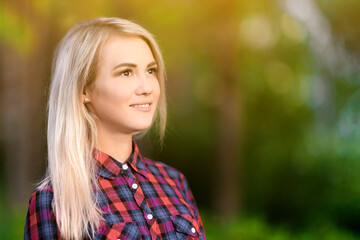 Fototapeta premium Blond beautiful girl smiles in the park.