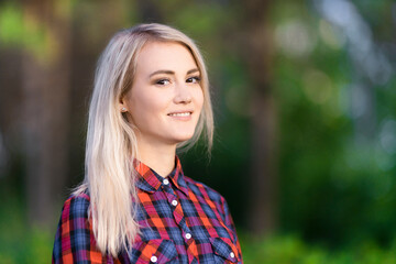 Fototapeta premium A portrait of a beautiful smiling girl in the park.