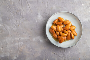 Almonds with honey on gray concrete. top view, close up, copy space.