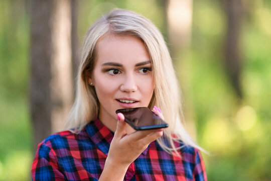 A portrait of a teen girl talking via speakerphone.