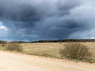Fototapeta premium simple rural landscape with a rural road, beautiful cumulus clouds