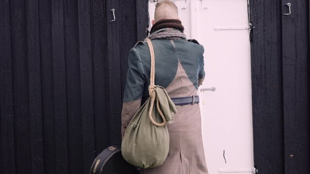 Stylish Man with  a Sack Bag and a Banjo Case Gets In the Little Black House