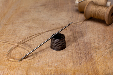 Metal Vintage thimble on wooden board fancy-work concept