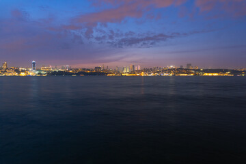 Panorama of Istanbul at night, long exposure with silky water and basques in movement, the tall buildings of the city are observed.