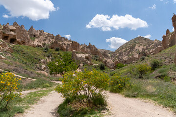 Landscape of the Red Valley of Cappadocia, with the volcanic mountains in the area and the blue sky full of white clouds.