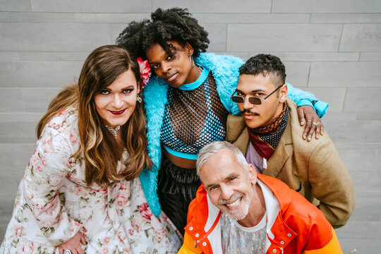 Portrait of smiling multiracial friends against wall