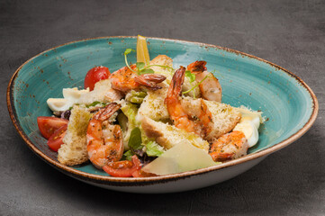 caesar with shrimp, croutons, parmesan and quail egg in a blue plate