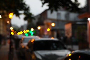 Blurred view of city street with parked cars in evening