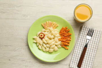 Tasty pasta served with juice on wooden table, flat lay. Creative idea for kid lunch