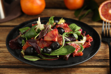 Delicious salad with sicilian orange on wooden table, closeup