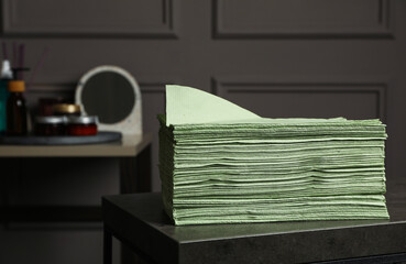 Stack of green paper napkins on grey table indoors. Space for text - Powered by Adobe