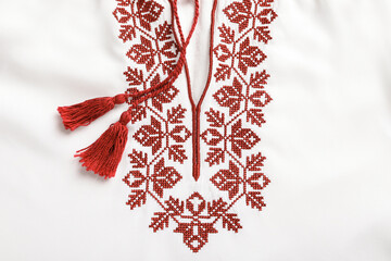Beautiful red Ukrainian national embroidery on white fabric, top view