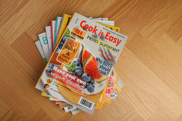 Many magazines on wooden background, top view. Space for text