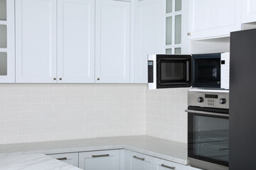 Modern oven and microwave in white clean kitchen