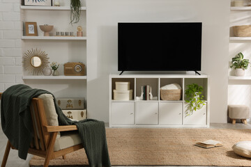 Stylish wide TV set on stand in room