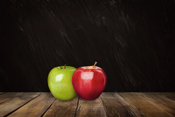Fresh ripe apples on wooden table near black chalkboard, space for text