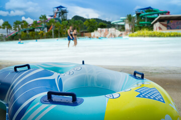 Focus at swim ring on the beach of ocean park, having beach party with people in swimming  pool and...