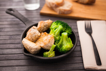 healthy appetizer of chicken pieces with broccol in small cast iron skillet