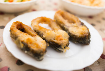 three pieces of fried carp on a white plate