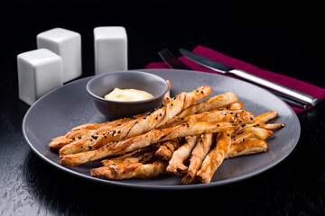 Breadsticks with cheese delicious snack. Grissini with cheese on a gray plate