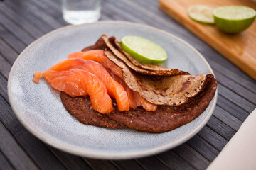 salted salmon fillet with buckwheat pancakes and lime