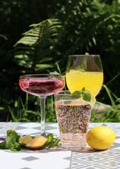 Romantic date in a park. Glasses with cocktails on a table. Refreshment concept. 