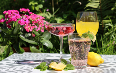 Romantic date in a park. Glasses with cocktails on a table. Refreshment concept. 