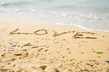 Word love written on the beach. Signs on the beach sand.