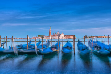Gondolas with San Giorgio Maggiore in the background in Venice, Italy just after sunset 