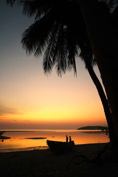 Silhouette of two people behind a boat after sunset in Koh Phangan