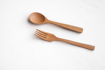 Kitchenware, a wooden spoon and fork on white top view