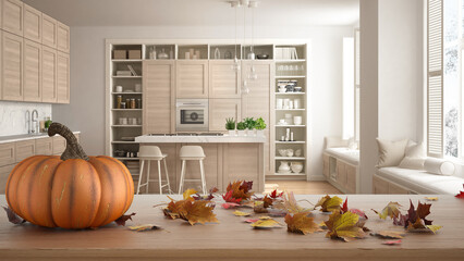 Autumn pumpkins still life on wooden table. Thanksgiving Halloween decoration over interior design scene. Scandinavian kitchen with island and windows with benches