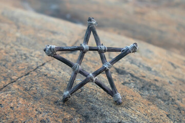 Pentagram made of small wood sticks on stone background. Esoteric and Occult concept. Mystic...