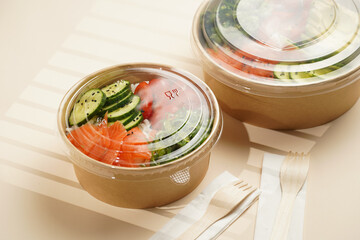 Trendy wholesome dish poke or buddha bowl - rice, wakame seaweed, tomatoes, cucumber, and red fish...