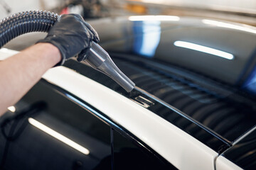 Man worker drying car on a car wash. Service car wash express. Worker uses turbo dryer to remove...